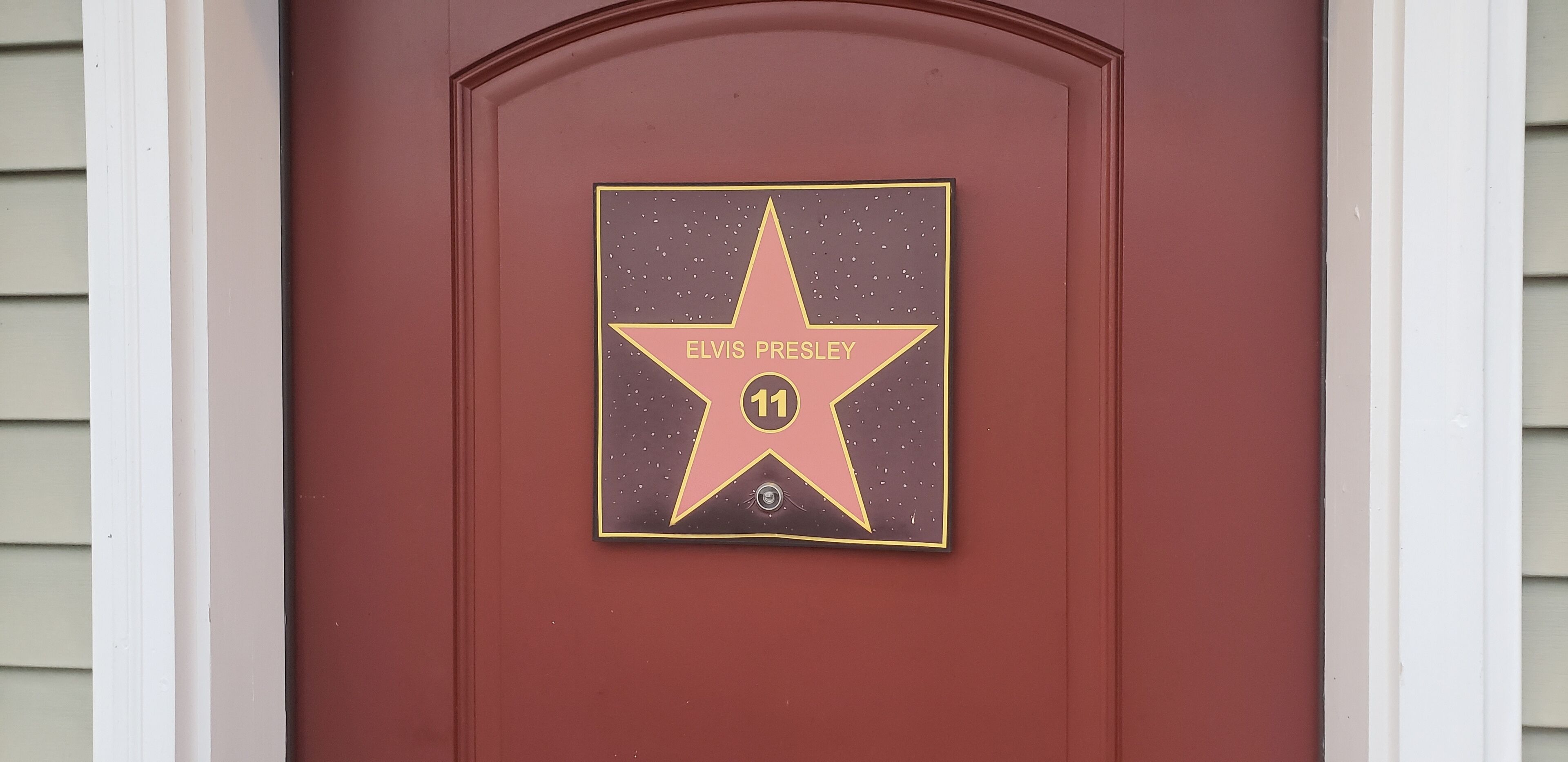 A star-shaped plaque with 'ELVIS PRESLEY' and the number '11' on a red door.