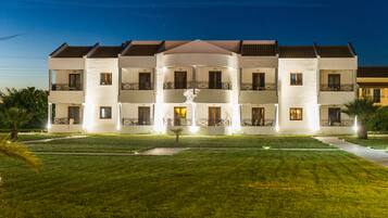 Vista frontal de la propiedad por la tarde o noche