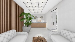 A modern reception area with a wooden panel wall, a reception desk, a large potted plant, and two white sofas. - Stemma Hotel (Corfu)
