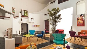 Un vestíbulo amplio con techo alto, muebles modernos y una planta grande.