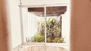 Ein Badezimmer mit Badewanne, Dusche und einem Fenster mit Blick auf Pflanzen.