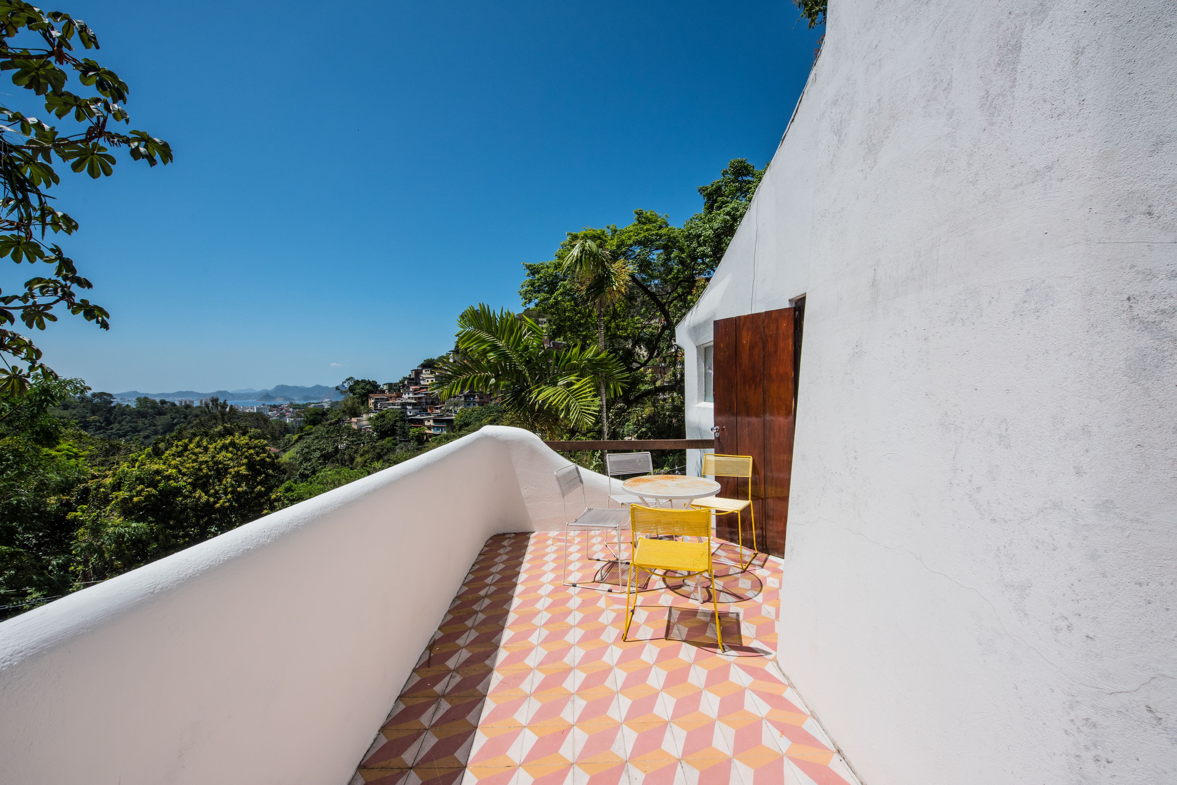 Ein Balkon mit Fliesenboden, einem Tisch und zwei Stühlen.