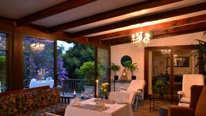 A dining area with a table set for four, a sofa, and a chair. - Highgrove House (Mbombela)