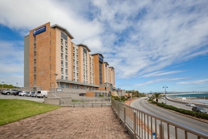 A hotel with a brick facade, multiple floors, and a parking lot. - Town Lodge Gqeberha (Gqeberha (Port Elizabeth))