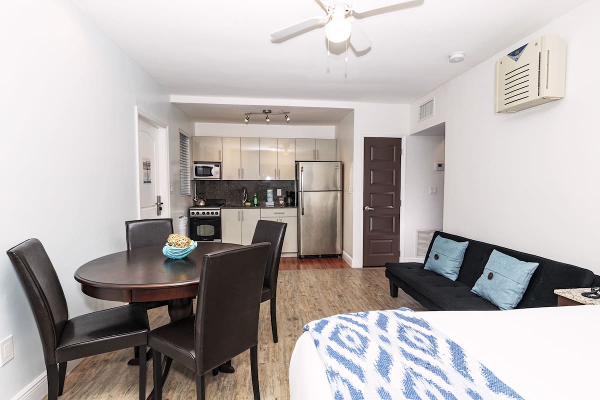 A compact living space with a dining area, kitchenette, and a sofa.