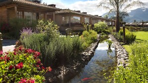 A wooden lodge with a garden and a small stream. - Hostería Cabañas del Lago (San Pablo del Lago)