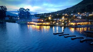 A riverside hotel with multiple buildings, a dock, and a calm water body reflecting the lights. - Hostería Cabañas del Lago (San Pablo del Lago)