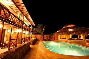 Una piscina al aire libre, sombrillas, sillones reclinables de piscina