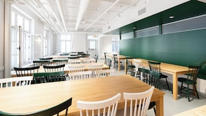 A classroom with tables and chairs, a large green chalkboard, and windows allowing natural light. - Auberge Internationale de Québec - Hostel (Québec City)