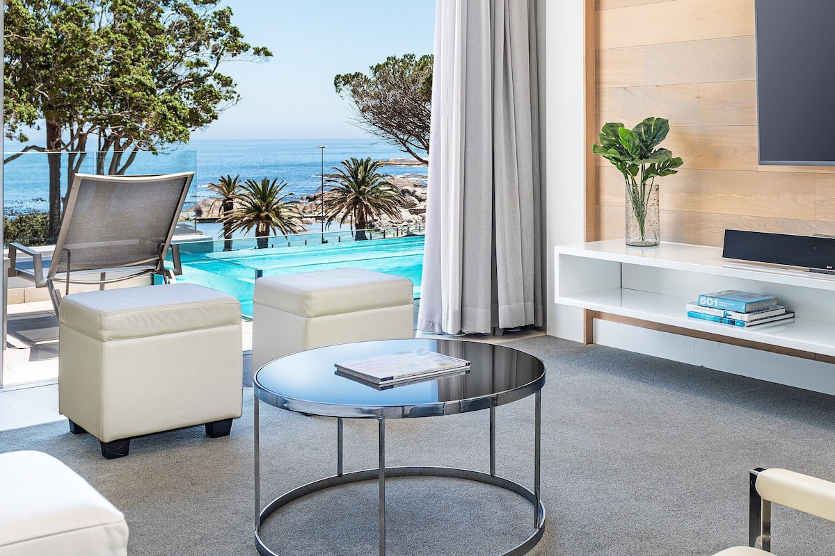A modern room with a pool view, a round table, and a white sofa.