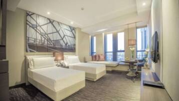 Een moderne hotelkamer met twee bedden, een bureau en een groot raam met uitzicht.