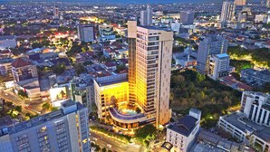 Un hotel moderno de gran altura con una entrada destacada y un amplio frente de vidrio.
