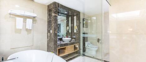 A modern bathroom with a large freestanding bathtub, a glass-enclosed shower, and a marble vanity.