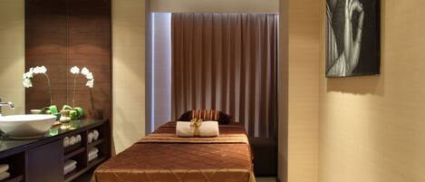 Habitación de hotel moderna con una cama grande, un baño con lavamanos y espejo, y un cuadro en la pared.