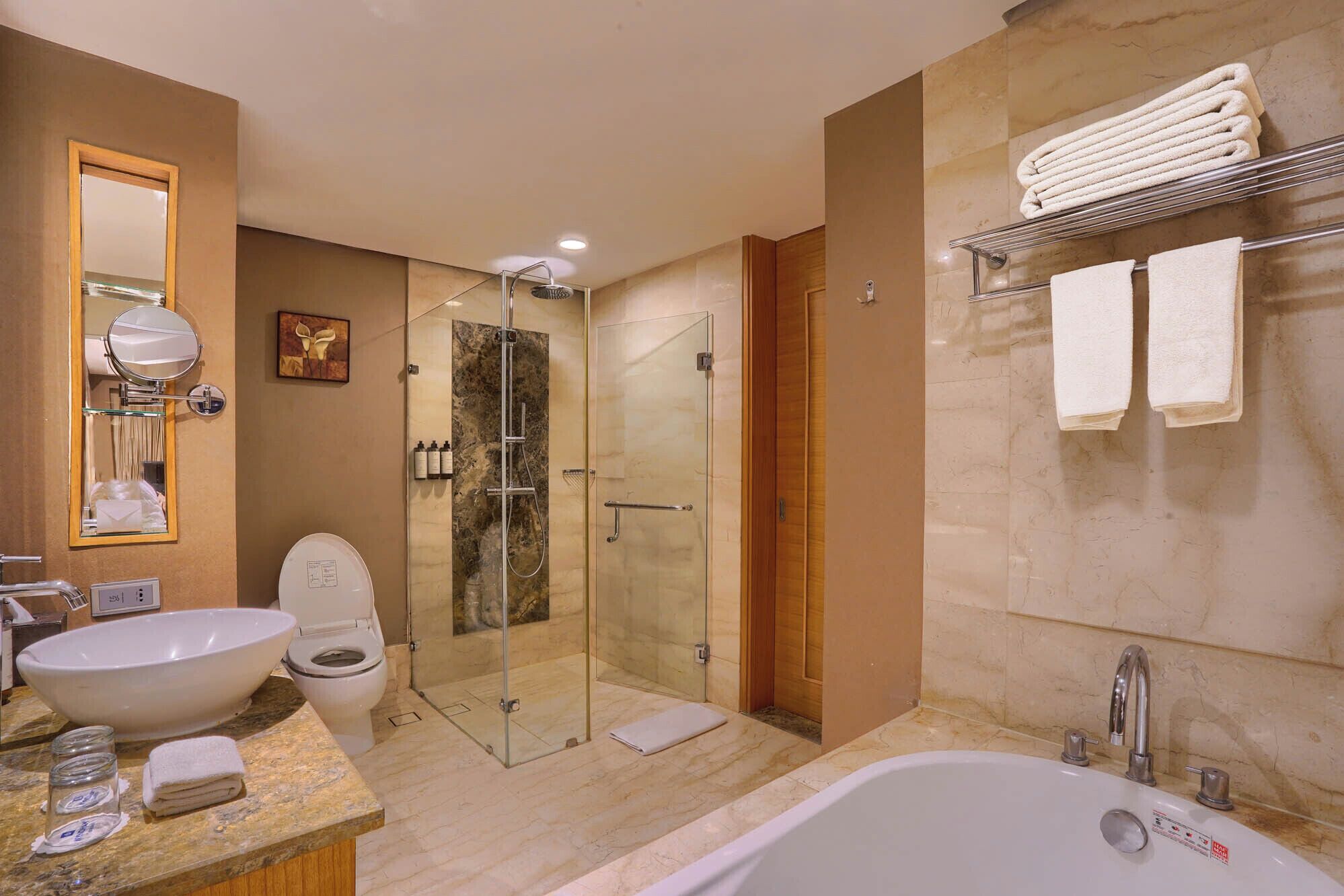 A modern bathroom with a glass-enclosed shower, a large bathtub, a sink, and a mirror.