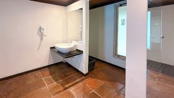 Un baño con un lavabo blanco, un espejo y una ventana.