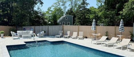 Una piscina al aire libre de temporada, sombrillas