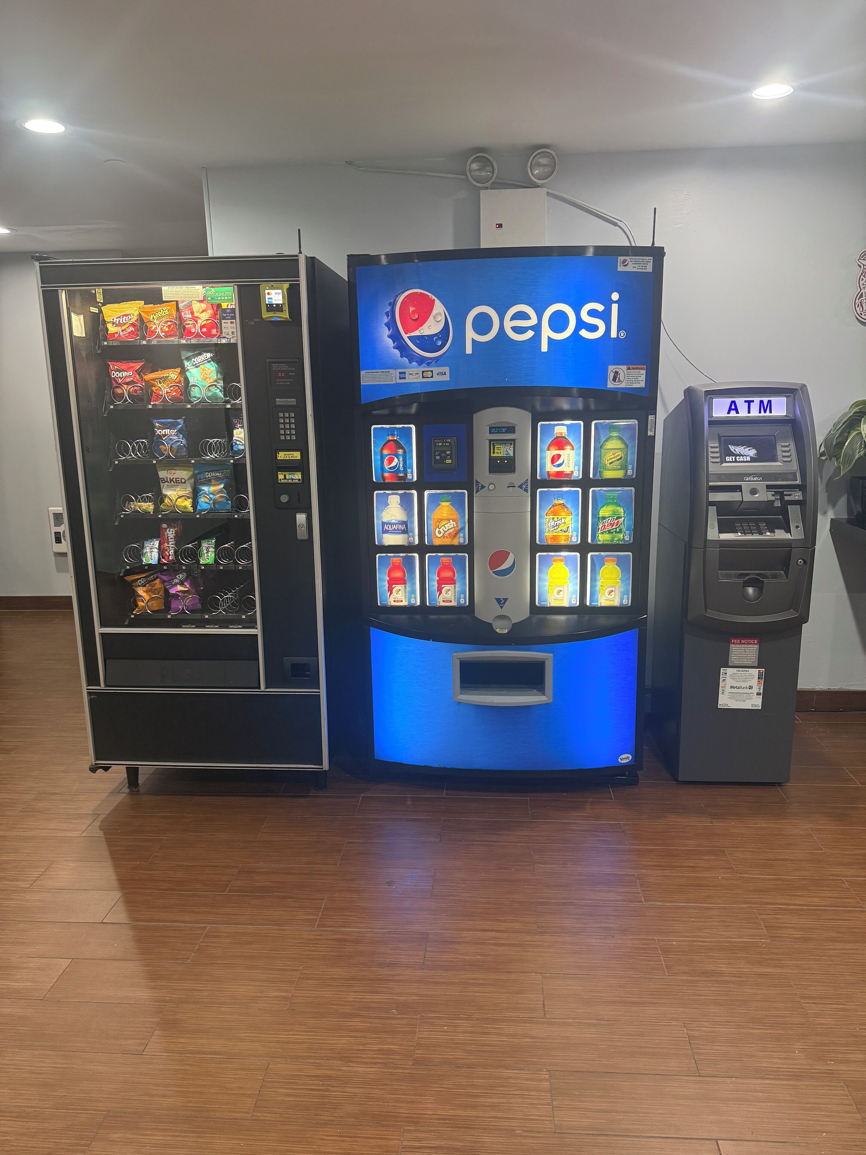 A vending machine with Pepsi branding, a separate snack vending machine, and an ATM.