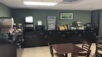 A restaurant with a counter, seating area, and kitchen appliances.