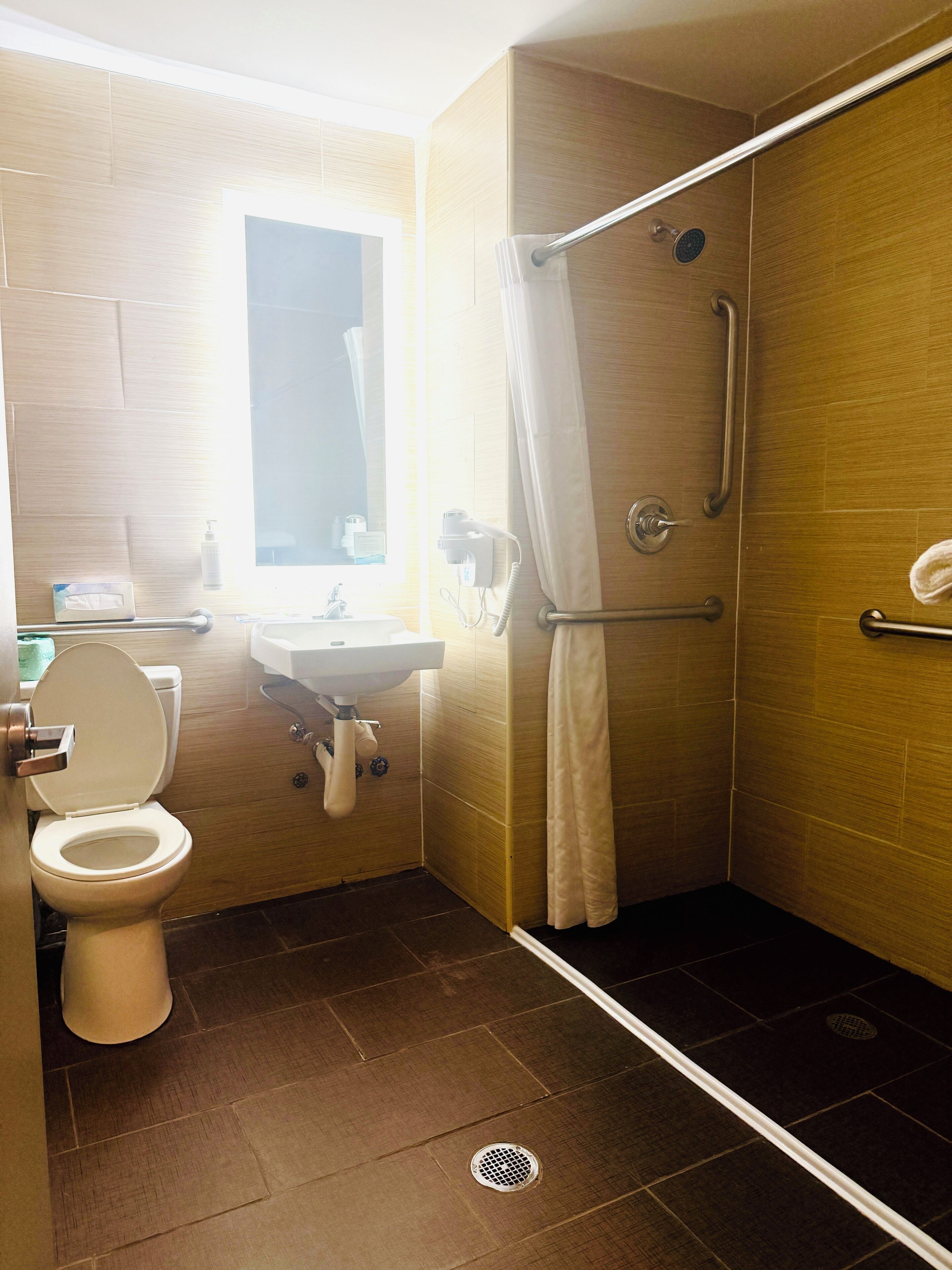 A bathroom with a toilet, sink, and shower.