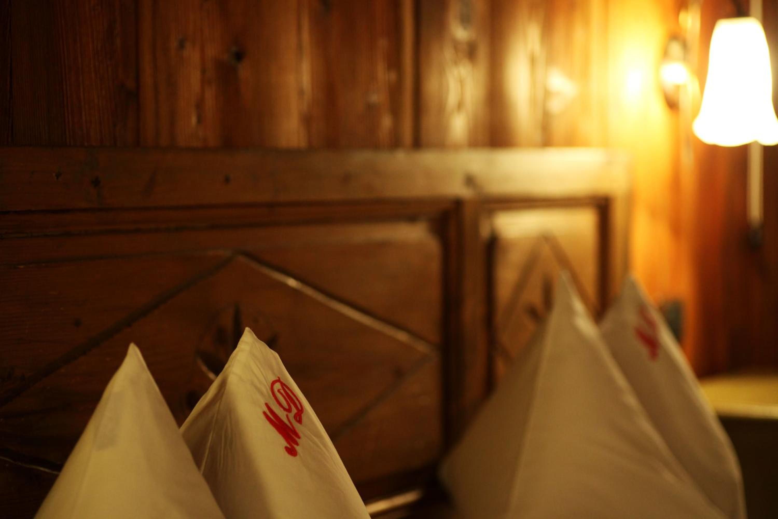 A row of white pillows with a red logo on a wooden headboard.