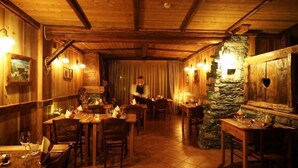Ein gemütliches Restaurant mit Holzeinrichtung, Steindekorationen und warmer Beleuchtung.