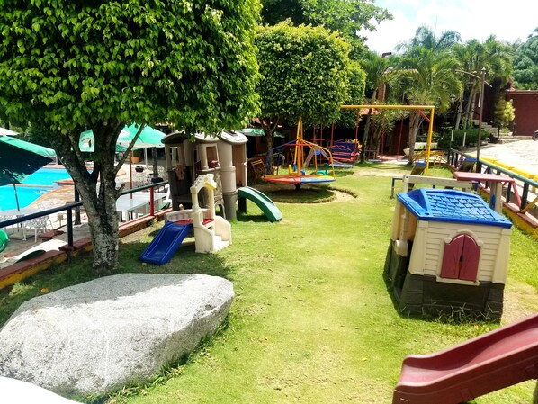 A playground with slides, swings, and a climbing structure.