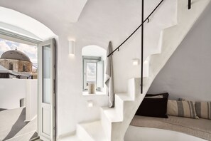 Un interior moderno con una escalera, un sofá y vistas a una estructura en forma de cúpula.