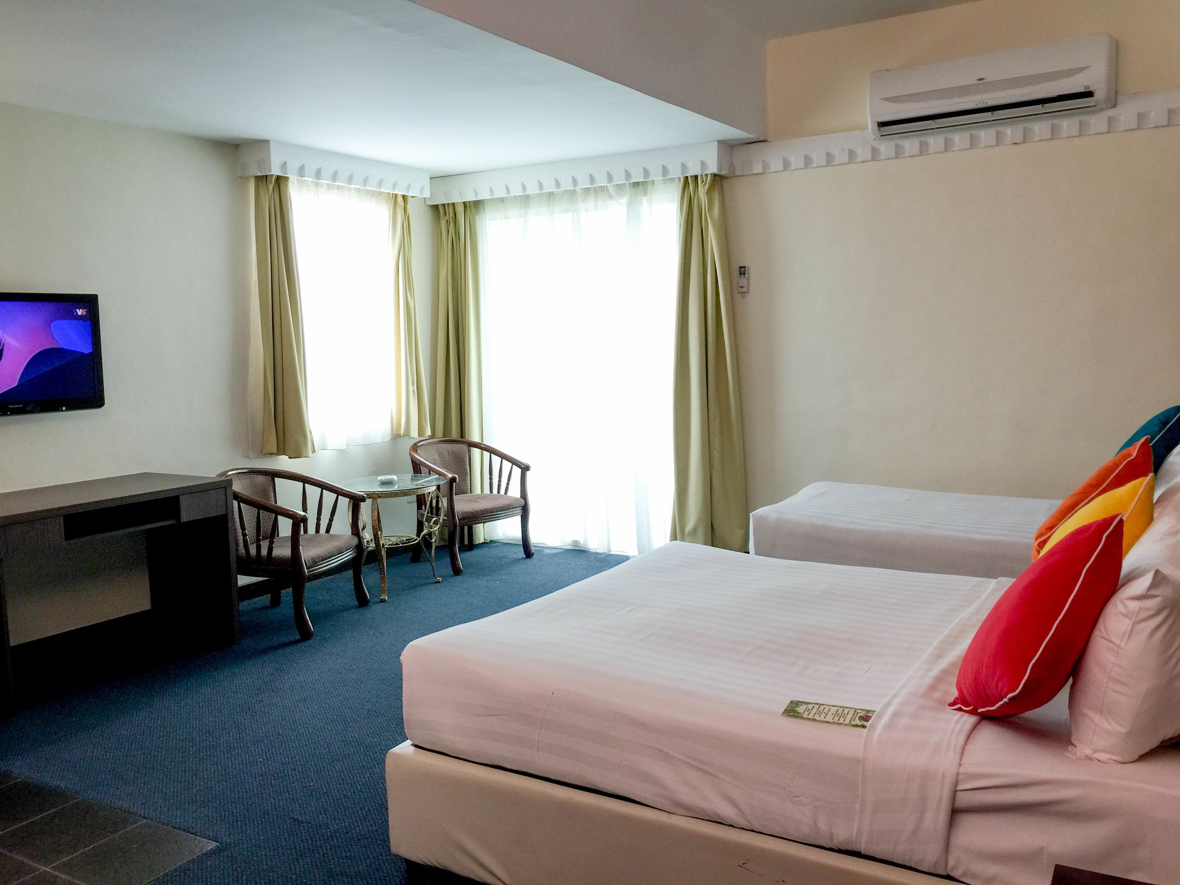 Une chambre d’hôtel avec un lit, un bureau et une télévision.