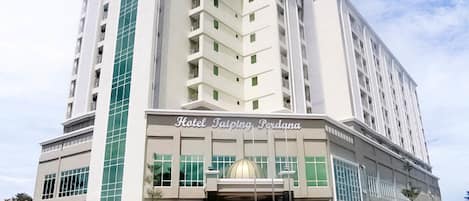 A modern hotel building with a prominent entrance and a large dome structure.