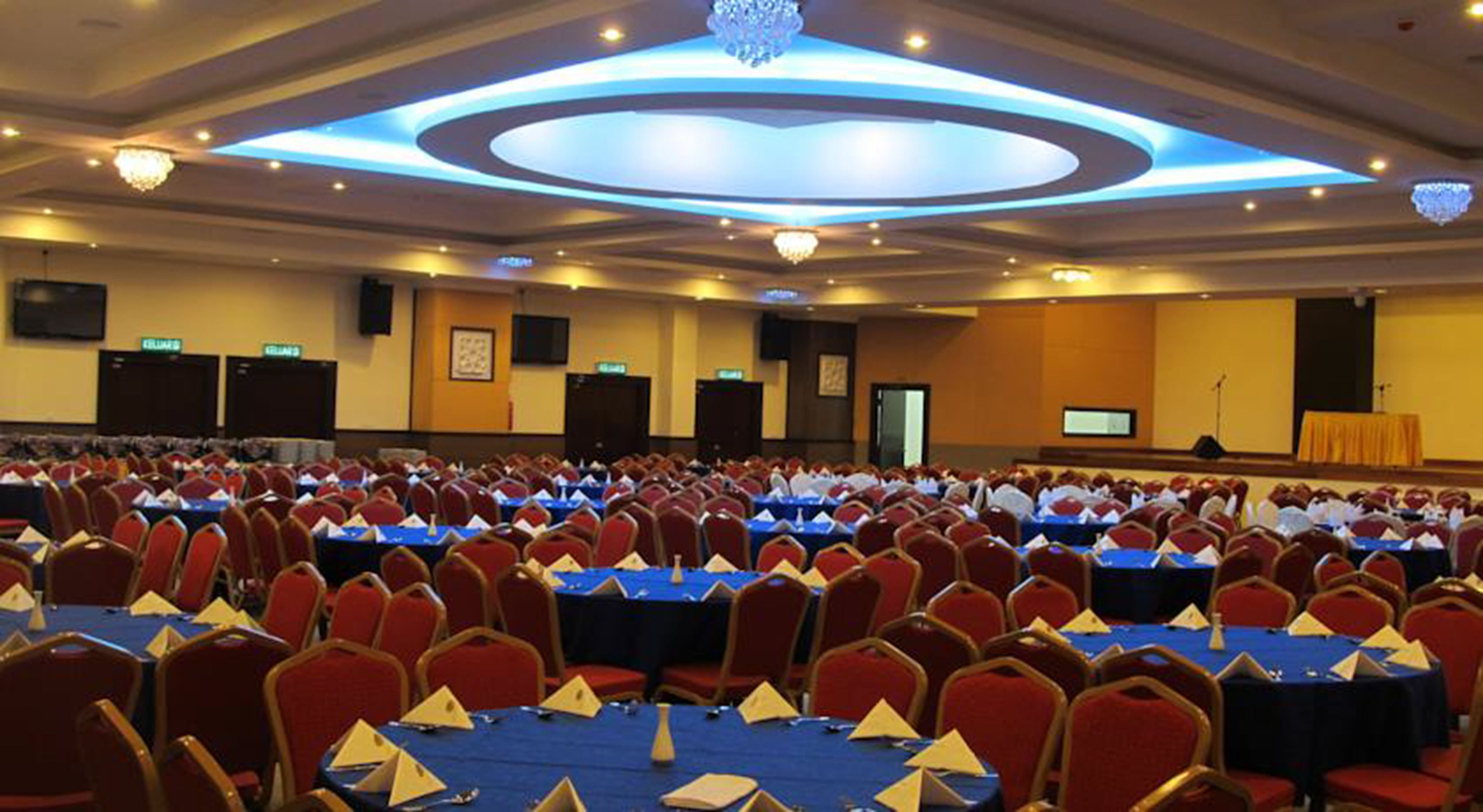 A conference room with rows of tables and chairs, equipped with nameplates and water bottles.