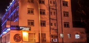 Un bâtiment doté de nombreuses fenêtres et d’une enseigne indiquant le « Kahama Hotel ».
