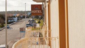 A hotel with a balcony featuring a wrought iron railing and a stone balustrade. - Hotel Mûita di Mari (Santa Teresa di Gallura)