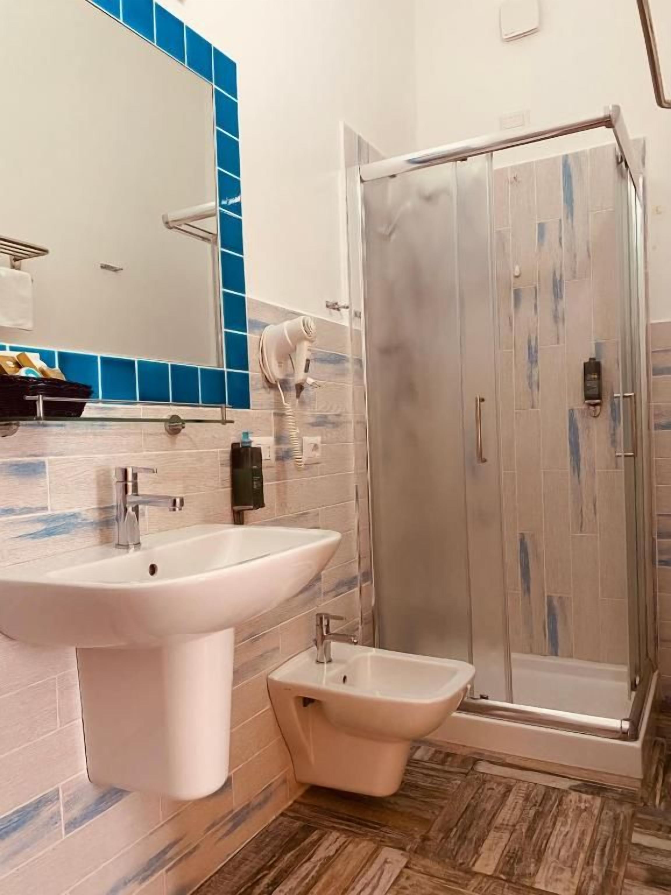 Un baño con cabina de ducha de vidrio, lavamanos y bidé.