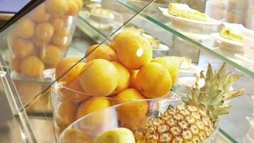 Une vitrine contenant des oranges et un ananas.