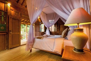 A room with a bed, a lamp, and a wooden door.