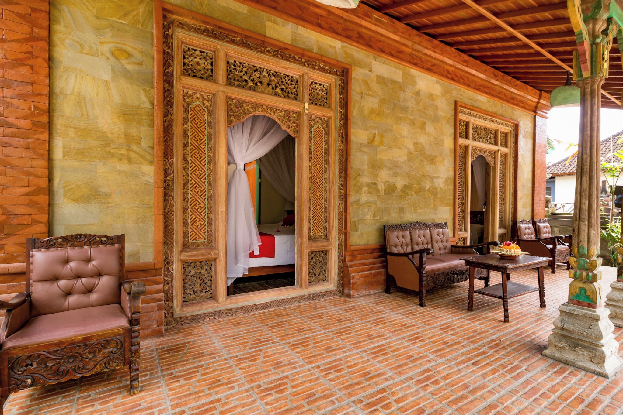 A traditional room with a bed, a wooden chair, and a table.