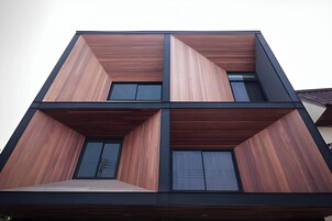 Un edificio moderno de varios pisos con fachada simétrica, ventanas grandes y techo plano.