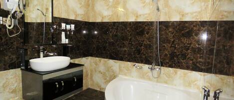 Baño con bañera blanca, lavamanos y espejo.