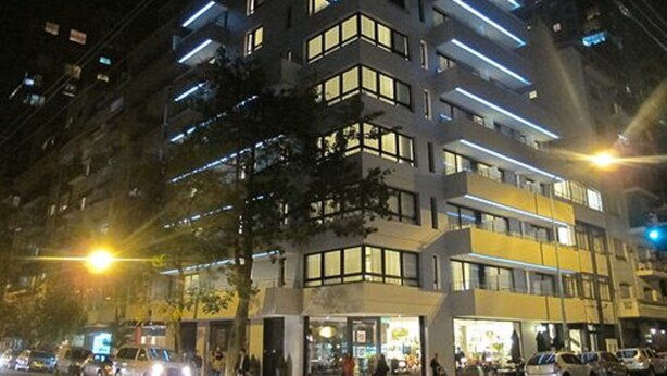 A multi-story hotel with a modern design, featuring balconies and large windows.