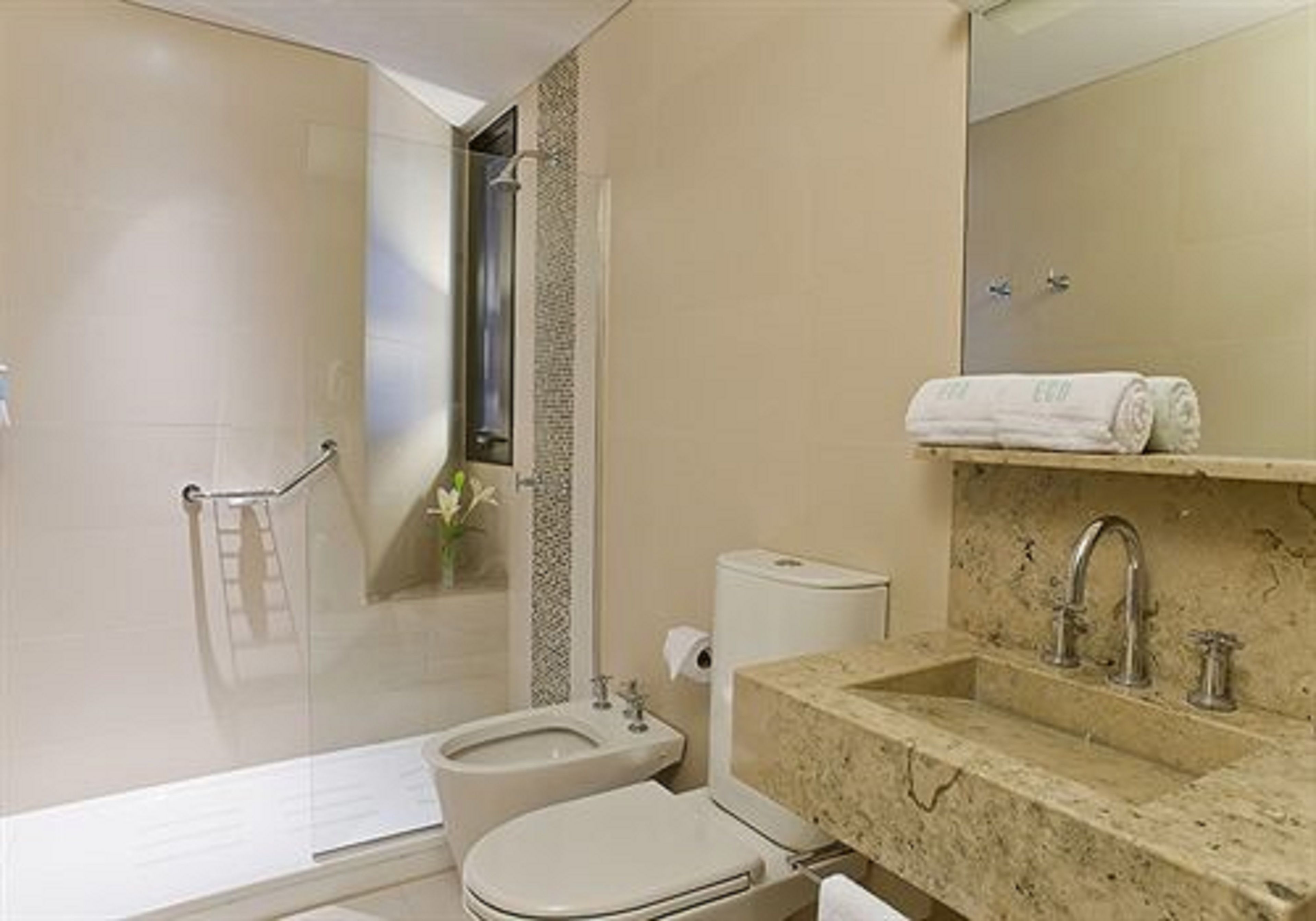 Un baño moderno con ducha, inodoro y lavamanos.