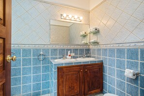 Une salle de bain avec deux lavabos, un miroir avec éclairage intégré et un meuble en bois.
