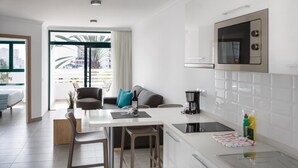 A modern kitchen with a dining area, a large window with a view, and a microwave above the counter.