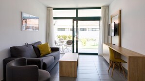 A modern living room with a sofa, coffee table, and a TV on a wooden stand.
