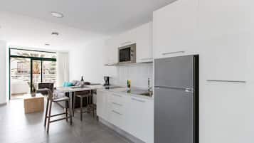 Apartamento superior, 2 quartos | Cozinha americana privada | Geladeira grande, micro-ondas, cooktop, cafeteira/chaleira