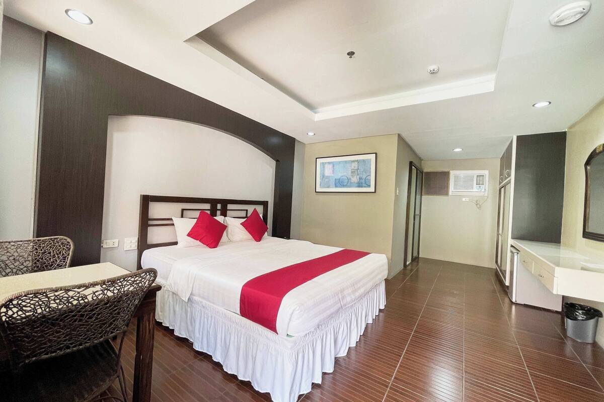 Ein Hotelzimmer mit Bett, Sessel, Schreibtisch und Bad.