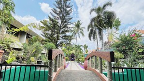 A pathway leading to a building with a covered entrance, surrounded by tropical vegetation. - Maharajah Hotel Angeles City (Angeles City)