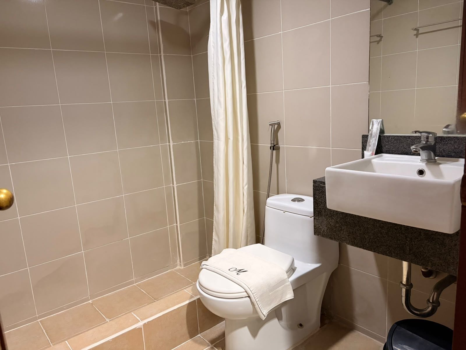 Un baño con ducha, inodoro y lavamanos.
