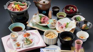 Una comida tradicional japonesa con varios platos, una tetera y palillos.
