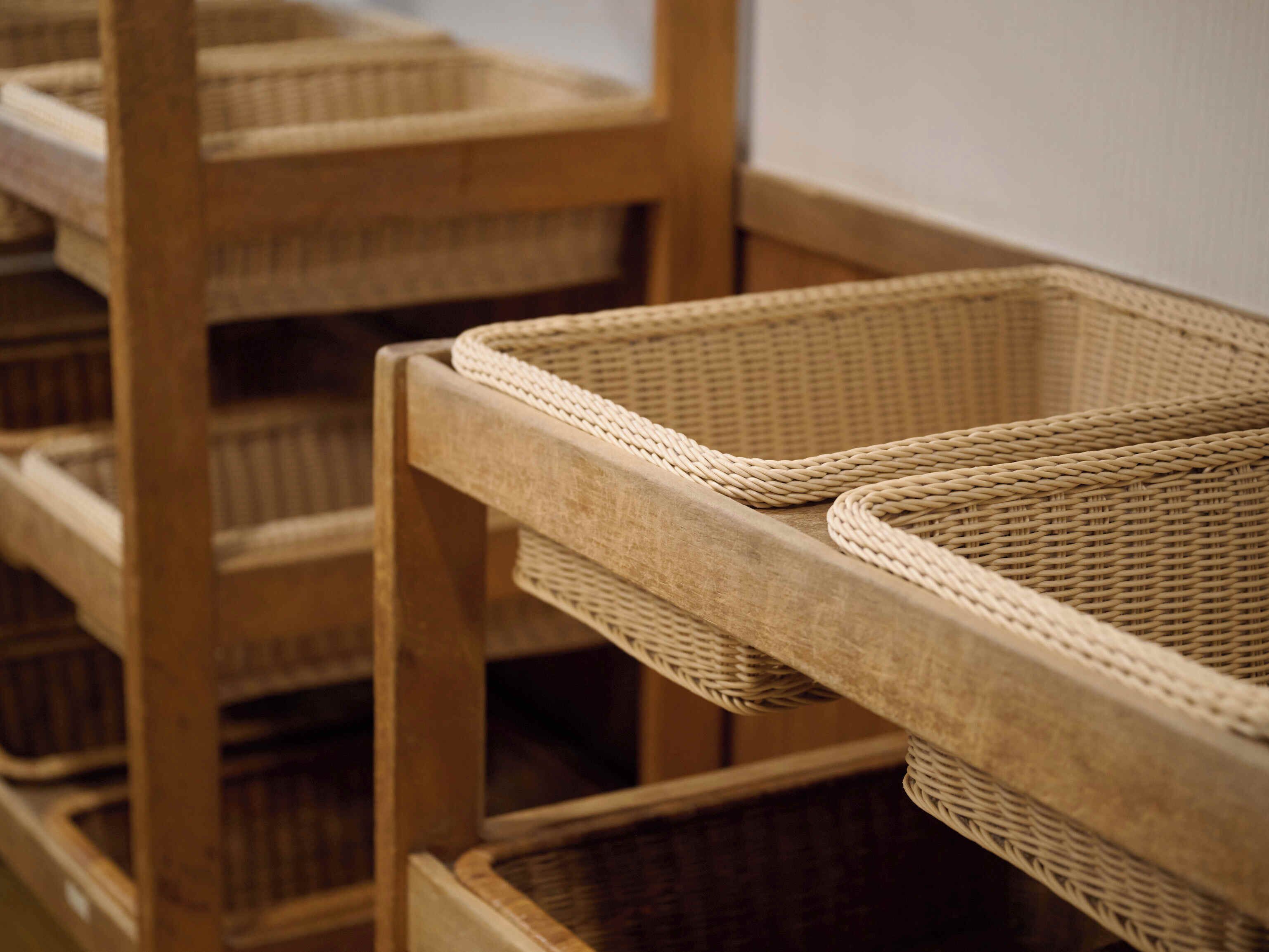 Wicker baskets stacked on wooden shelves.